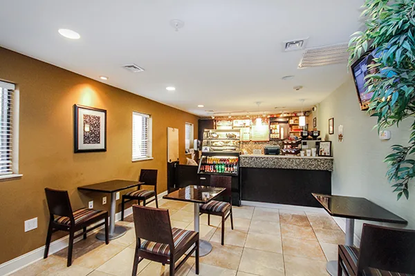 A dining area with tables and chairs, a counter, and a TV.