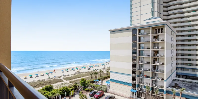 A beachfront property with a balcony overlooking the ocean and beach.